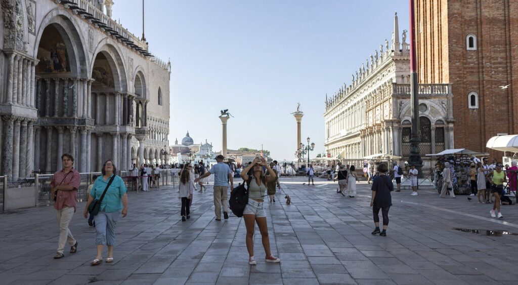 FILE PHOTO: Tourists walk in Piazza San Marco, the most important square in Venice, on the weekend of the wedding of American billionaire Jeff Bezos in Venice, Italy, on June 27, 2025.