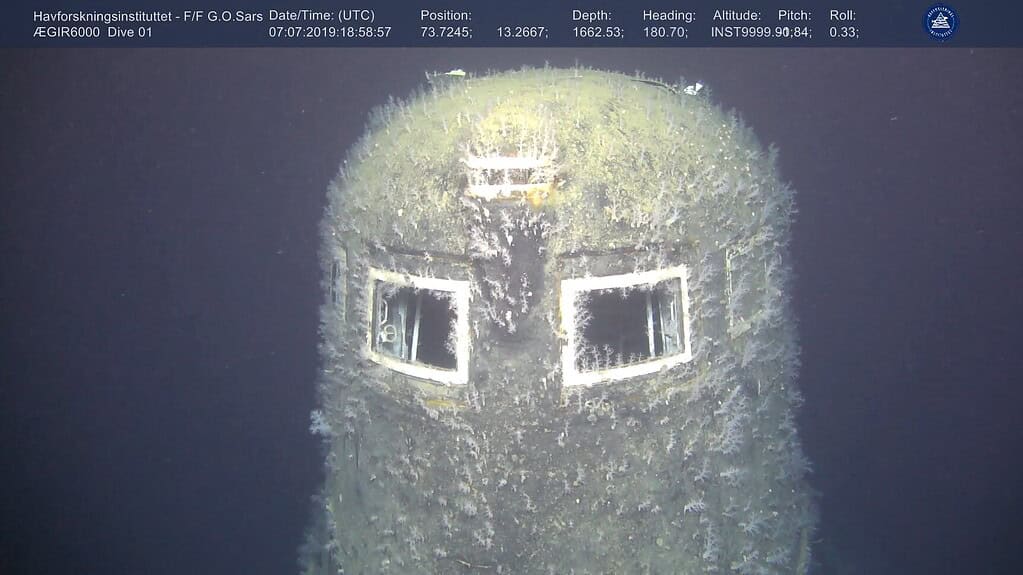 Image of a section of the sunken nuclear submarine, surrounded by deep blue water and.