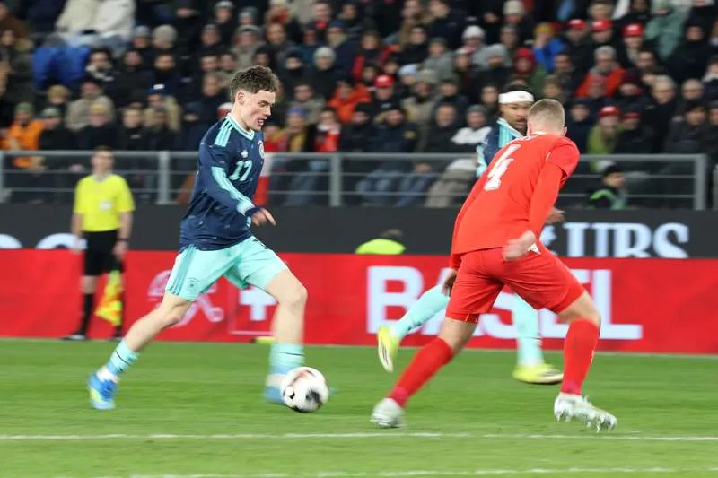 Germany's Florian Wirtz (L) and Switzerland's Nico Elvedi battle for the ball during the International Friendly soccer match between Switzerland and Germany at St. Jakob-Park. Christian Charisius/dpa