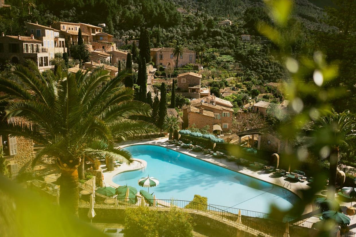 serene view of a pool surrounded by lush greenery and historic buildings