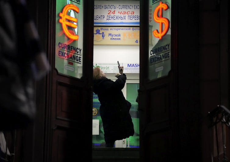 A woman stands in the doorway of a building