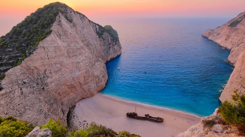 A view of Greece's Navagio Beach, also known as Shipwreck Beach, from above, showing a shipwreck on white sand