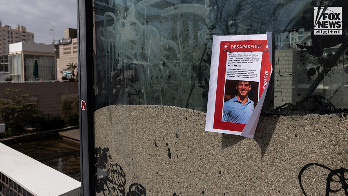 A missing person flyer for Alabama student James Gracey posted along a shoreline and marina.