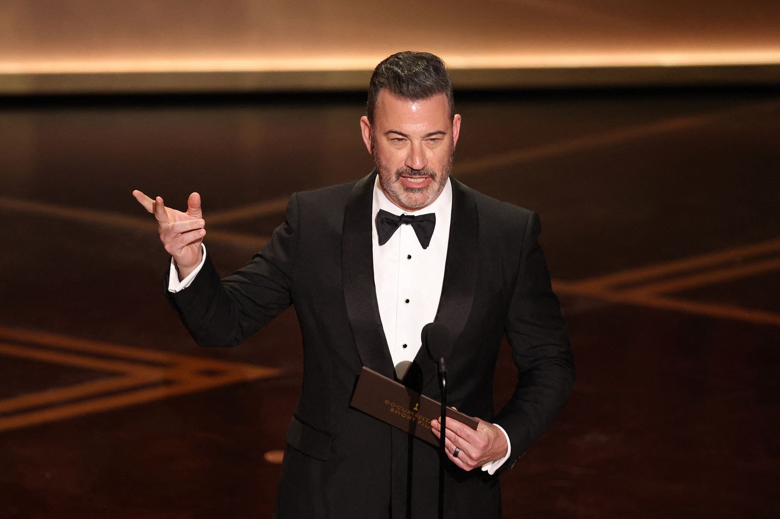 Image may contain Jimmy Kimmel Clothing Formal Wear Suit Tuxedo Adult Person Crowd Electrical Device and Microphone