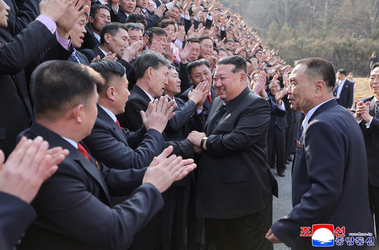 North Korean Supreme Leader Kim Jong-un (second from right) shakes hands with mine workers in the South Pyongan Province on March 15. (Yonhap)