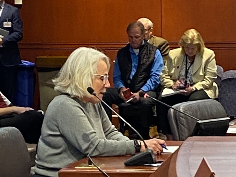 woman reading testimony into microphones
