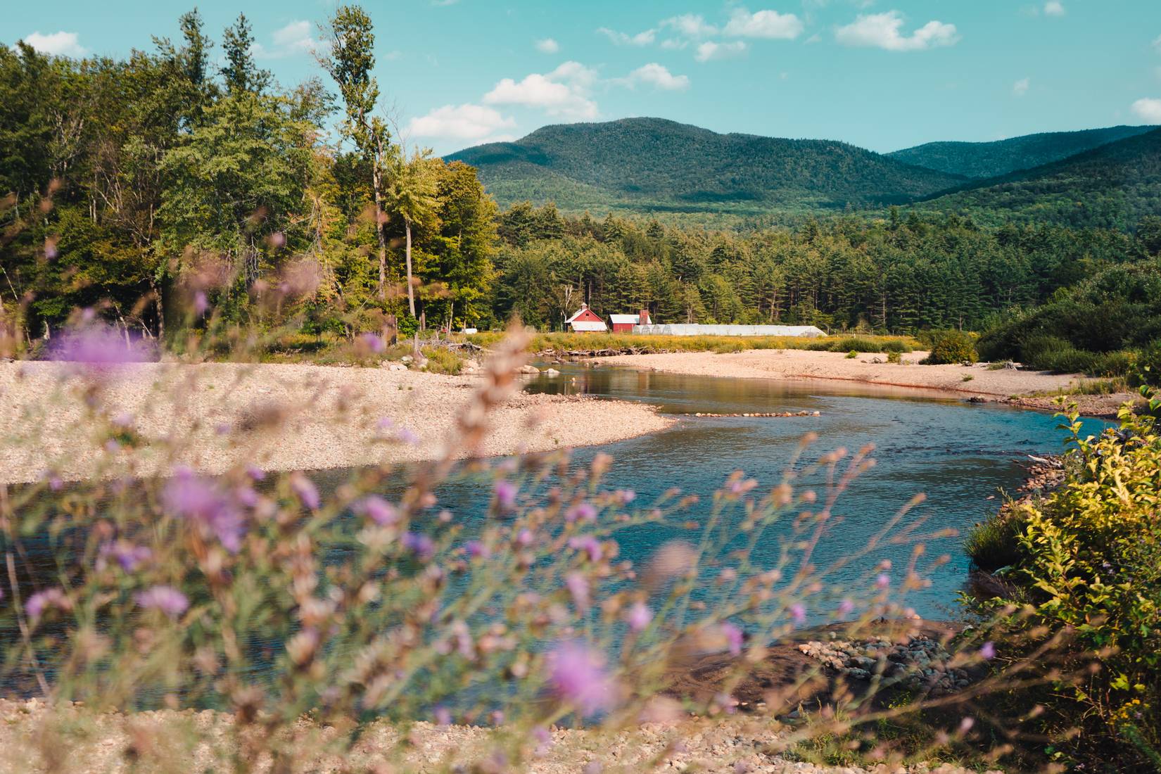 A small farm set in the valley alongside a river in Keene, New York 