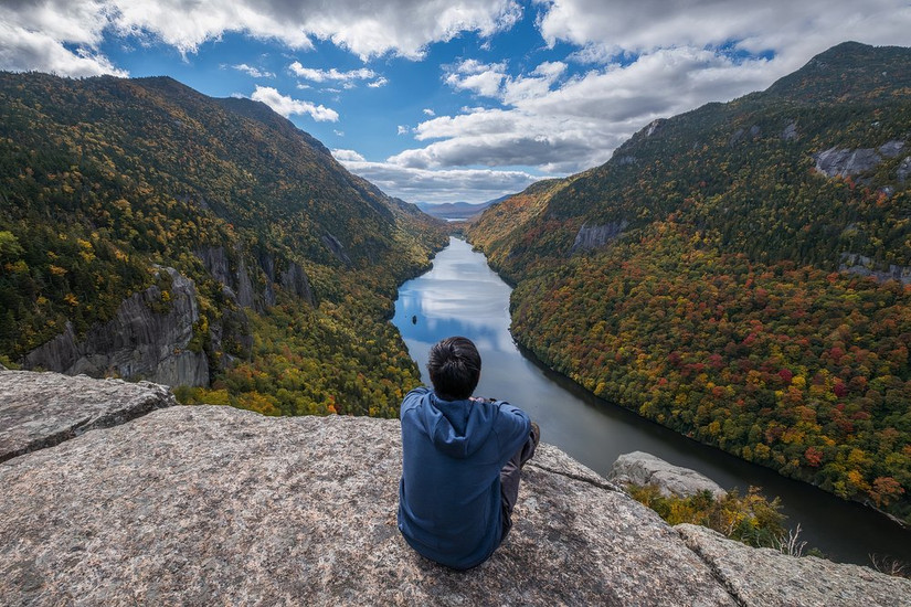Man sitting on Indian Head Cliff at Adirondack Park, New York, USA