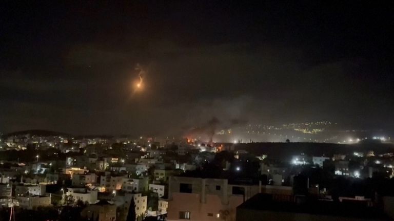 Smoke rising in Deir al-Hatab with what appears to be a military flare overhead as seen from Salem village. Pic: AP