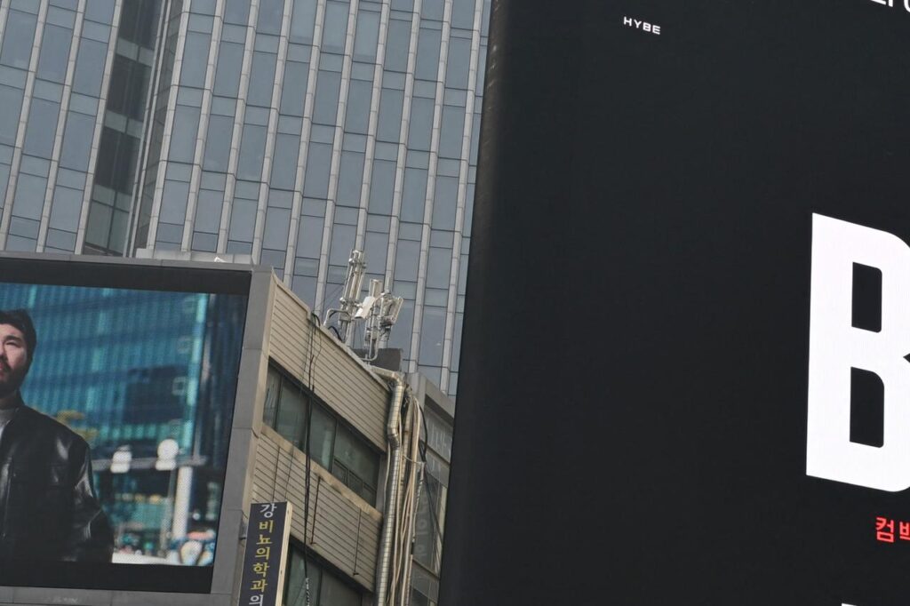 People walk past a BTS comeback concert billboard at Gwanghwamun Square in Seoul, South Korea, March 17, 2026. (AFP Photo)
