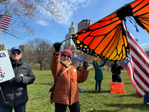 Chris Lange of Enfield waves a Monarch butterfly flag along with an American flag at the "No Kings" protest at the Connecticut State Capitol on Saturday, March 28. (Stephen Underwood/Hartford Courant)