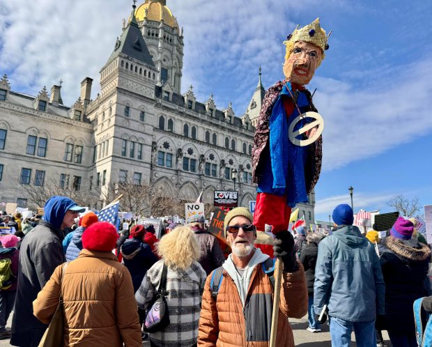 Jay Ames of Storrs holds a puppet of Donald Trump he created himself at the "No Kings" rally at the Connecticut State Capitol in Hartford on Saturday, March, 28. (Stephen Underwood/Hartford Courant)