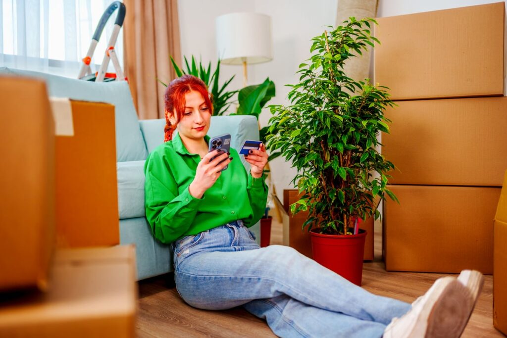 Person looking at a phone in one hand and a credit card in the other.