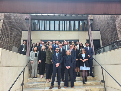 A group of professionals standing on stairs. Representatives of the Joint US-NZ space dialogue