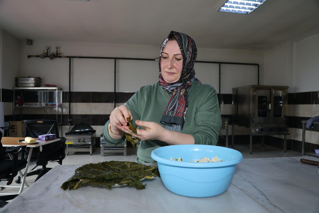 Regional cuisine instructor Elif Kalkan wraps the lor cheese filling with evelik leaves while preparing traditional lor dolmasi in Bayburt, Türkiye, March 14, 2026. (AA Photo)