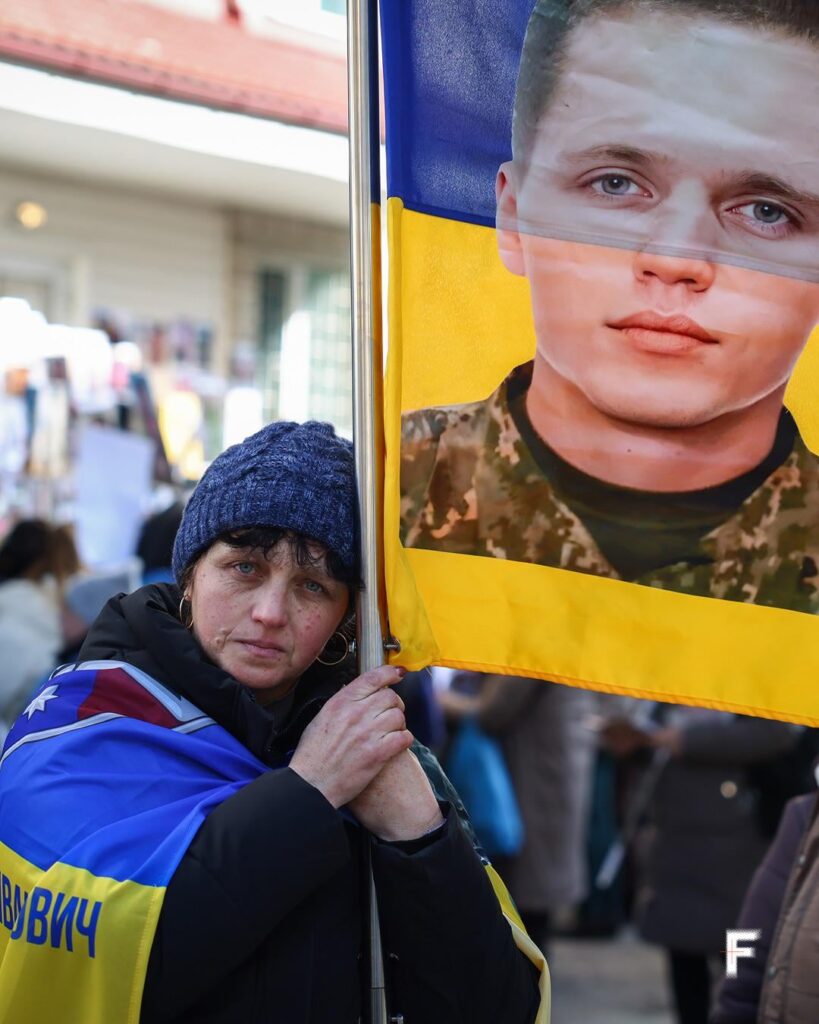 The Sun has Set Over Kyiv on the 1571st Day of the Full-Scale Invasion. Woman holds sign for Ukrainian soldier whose fate is unknown during POW exchange
