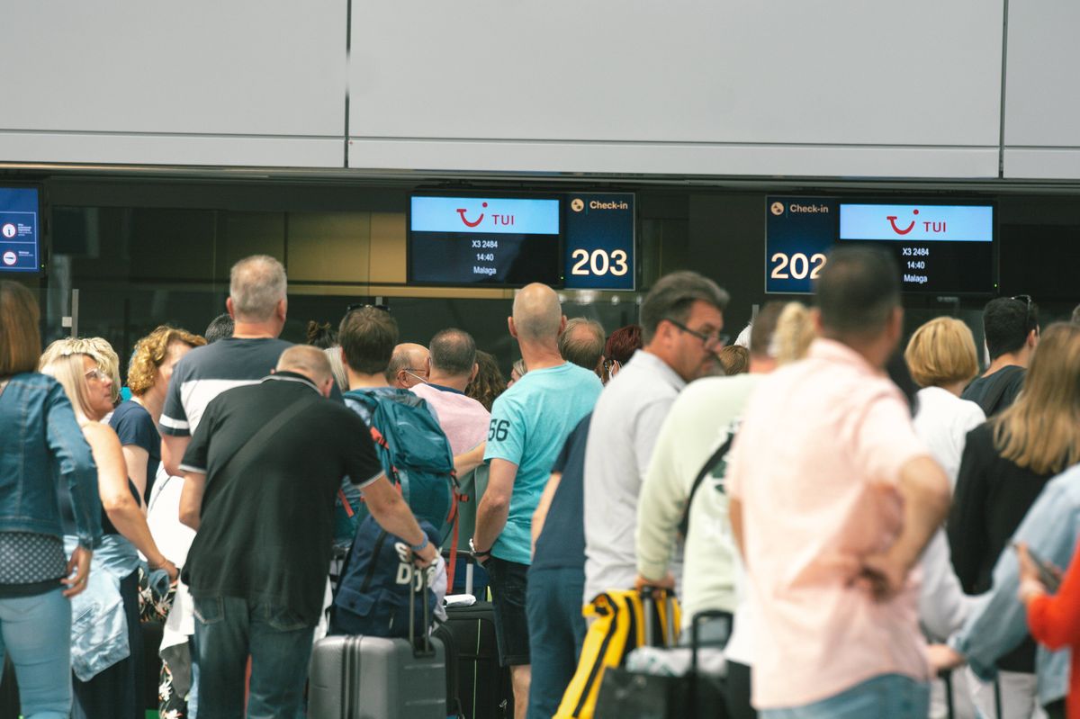 people wait in a long line in front of Tui Airways checkin counter at Duesseldorf airport on June 3, 2022 before the Pentecost holiday weekend. (Photo by Ying Tang/NurPhoto via Getty Images)