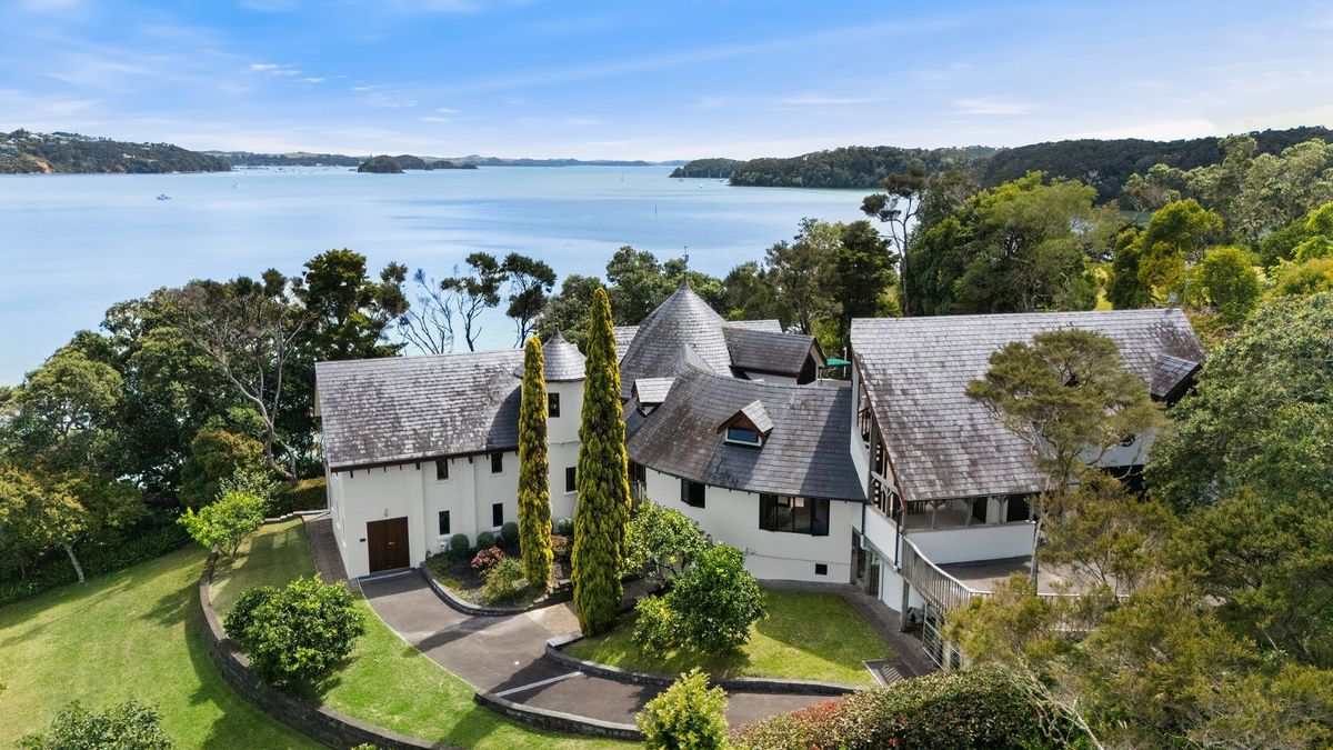 Aerial view of white-washed house next to the water in New Zealand in the Bay of Islands for sale design based on Castell Coch and called Castell Bach with agent Mackys Real Estate part of Bayleys Realty Group for over $3m New Zealand dollars