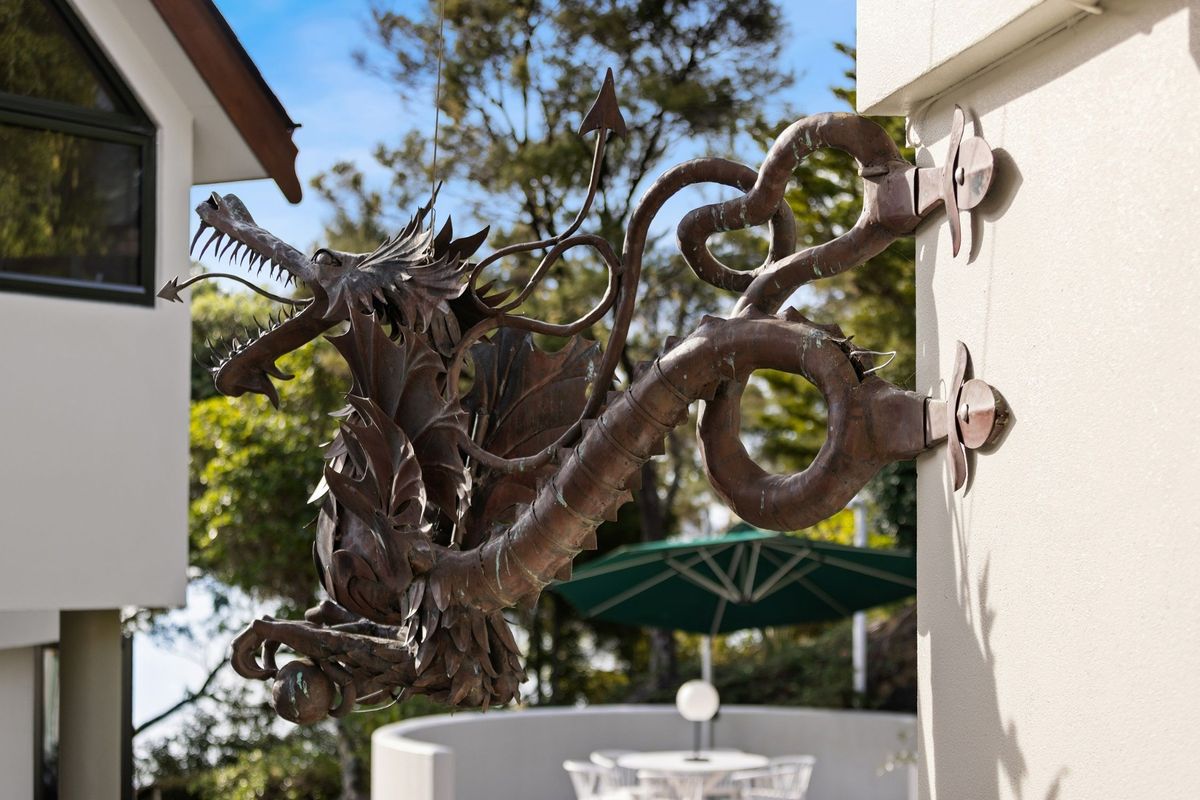 Metal dragon sculpture mounted onto an exterior wall at a House in New Zealand in the Bay of Islands for sale design based on Castell Coch and called Castell Bach with agent Mackys Real Estate part of Bayleys Realty Group for over $3m New Zealand dollars
