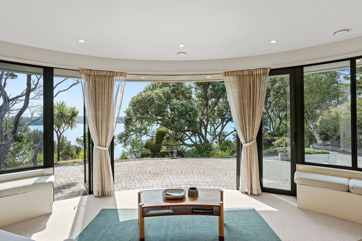 Ground floor of tower is the open-plan lounge, kitchen dining area with curved walls, windows and doors at a House in New Zealand in the Bay of Islands for sale design based on Castell Coch and called Castell Bach with agent Mackys Real Estate part of Bayleys Realty Group for over $3m New Zealand dollars 