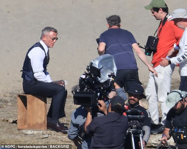 Daniel - whose silver grey locks were on display - perched on a wooden box while watching Cillian's character in action