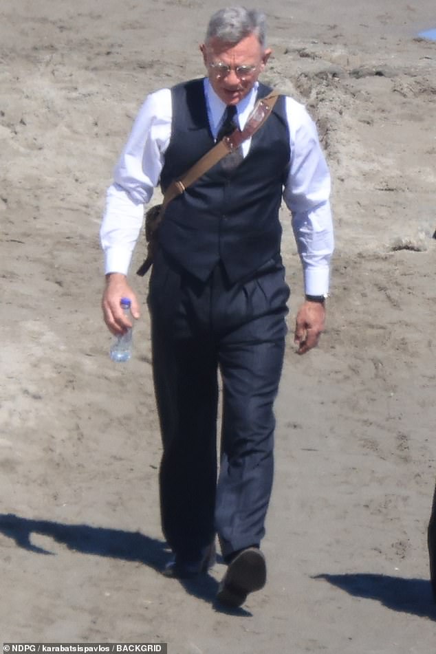 The star was seen carrying a bottle of water as they walked between takes