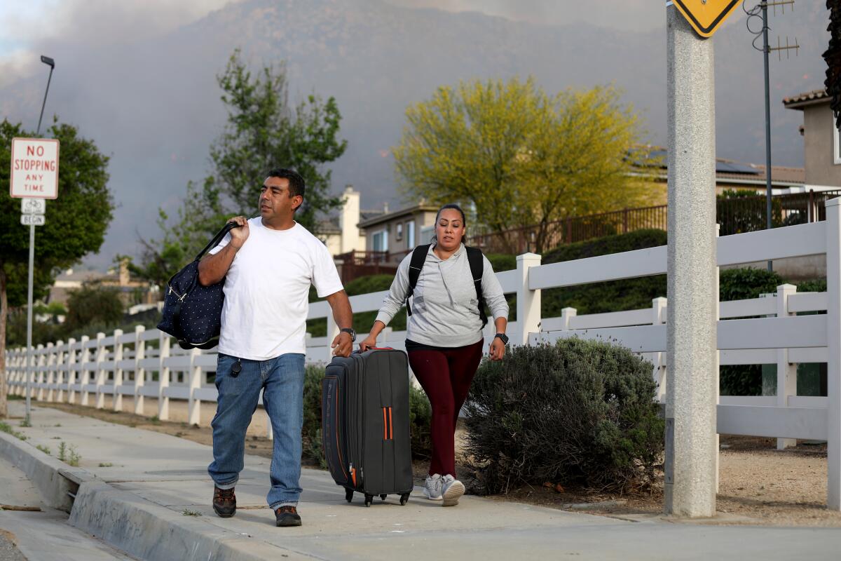 Residents evacuate their homes while Cal Fire Riverside fights the Springs Fire.
