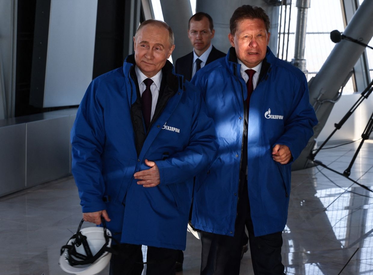 Russian President Vladimir Putin (L) walks with Gazprom CEO Alexei Miller (R) 