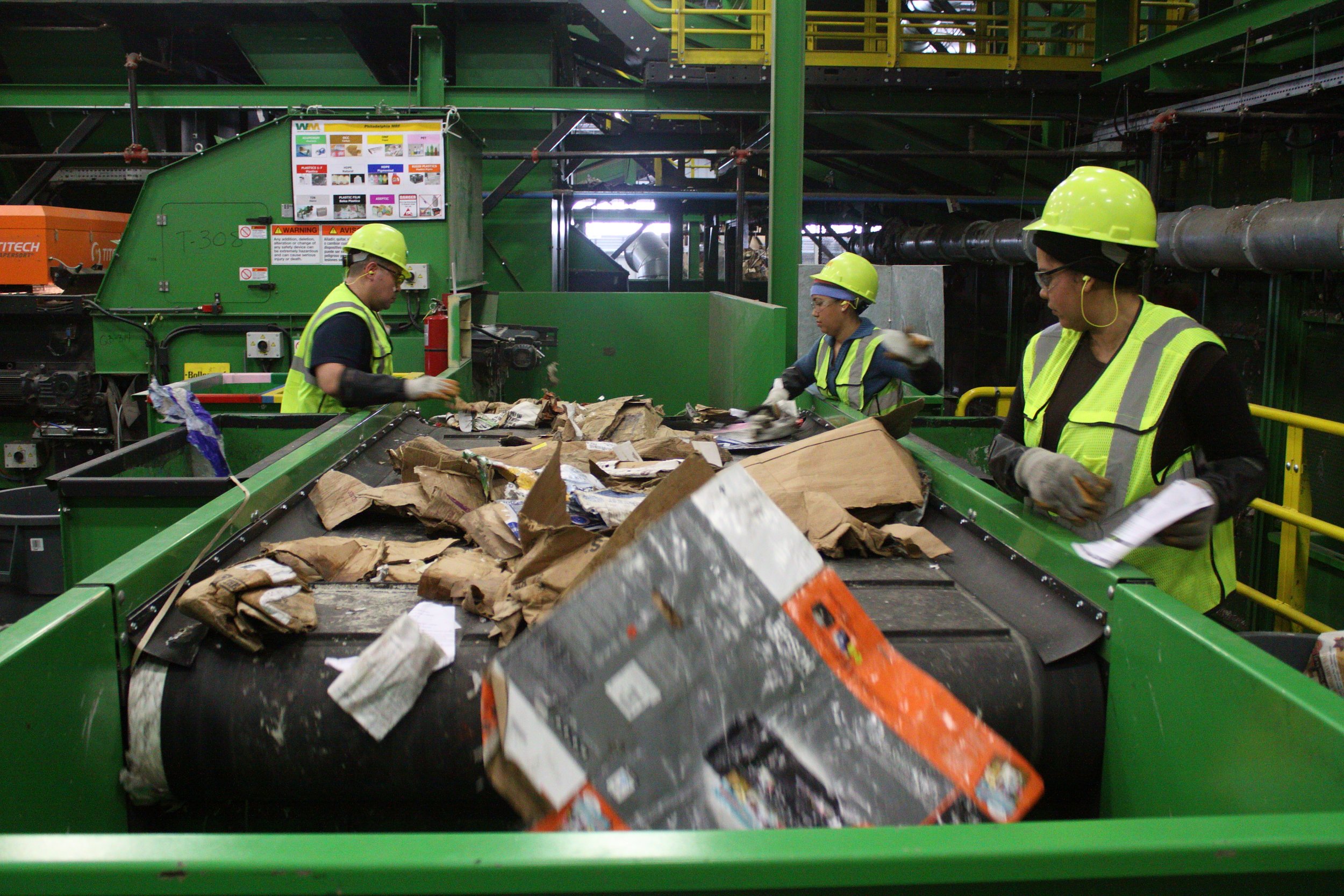 Employees work at a waste collection facility.