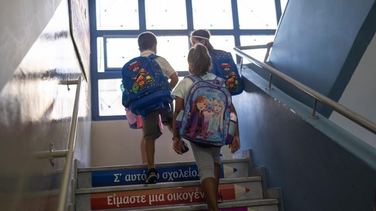 Students walk up stairs to enter their class during their...