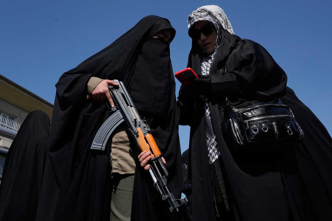 A woman member of the Basij paramilitary, affiliated with Iran's Revolutionary Guard, holds her gun during a state-organized rally in support of the supreme leader marking National Girl's Day in Tehran, Iran, Friday, April 17, 2026.