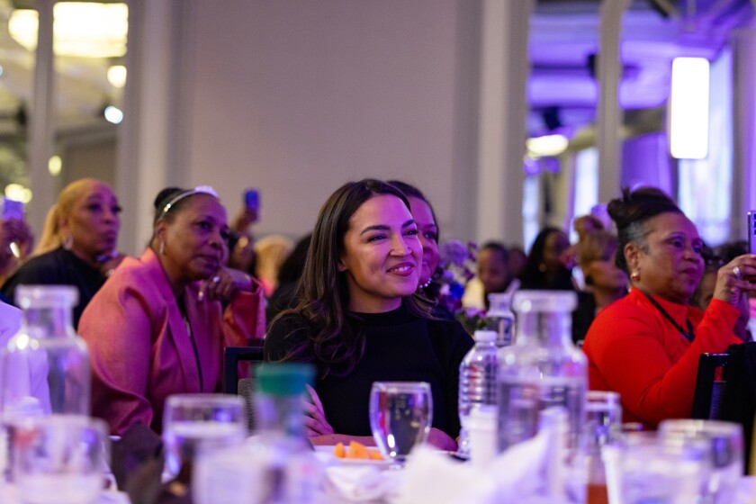 U.S. Rep. Alexandria Ocasio-Cortez listens to Harris speak during the “Power Rising" summit.
