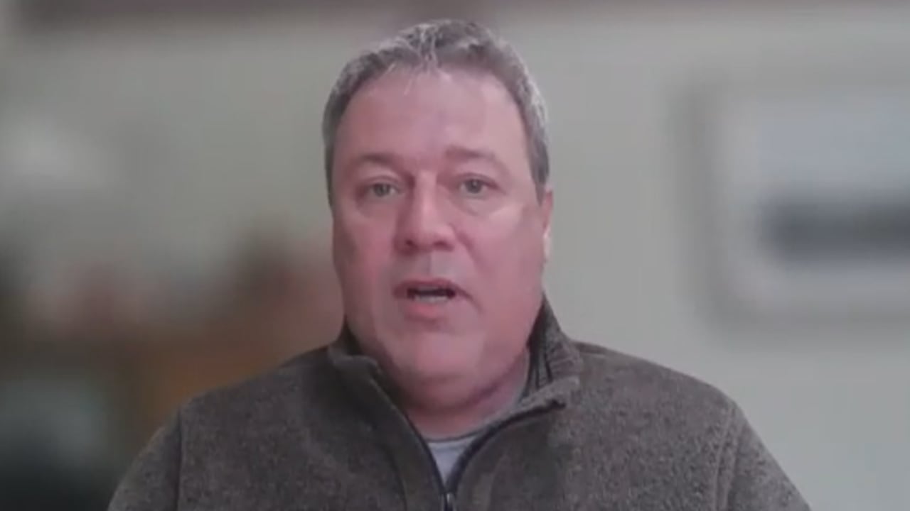 A man in a grey quater-zip