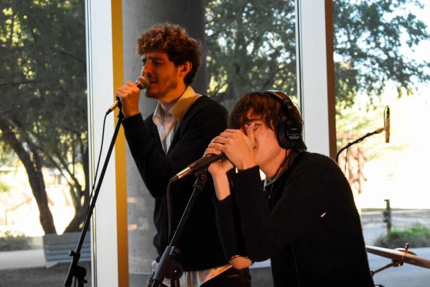Two men singing into microphone