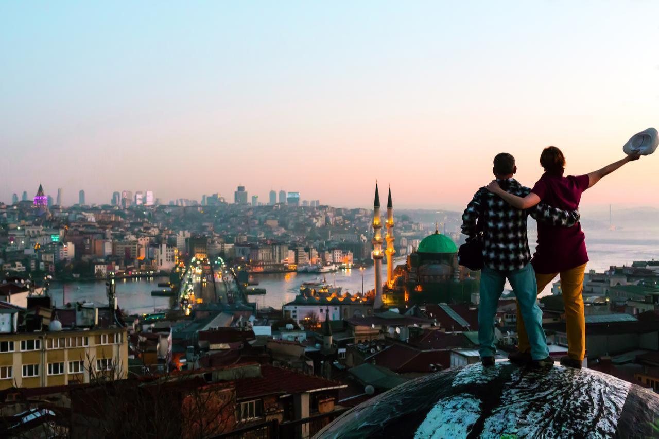 Tourists admire the sunset over Istanbuls Golden Horn, with Galata Tower and the citys skyline in view, Türkiye, accessed June 25, 2025. (Adobe Stock Photo)