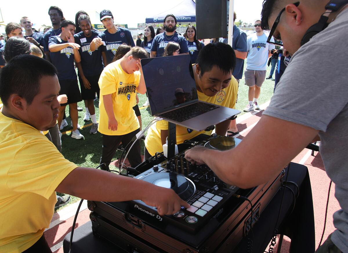 DJ Nick Nack gets help playing music at the turntable from special education students at Edison High School on Thursday.
