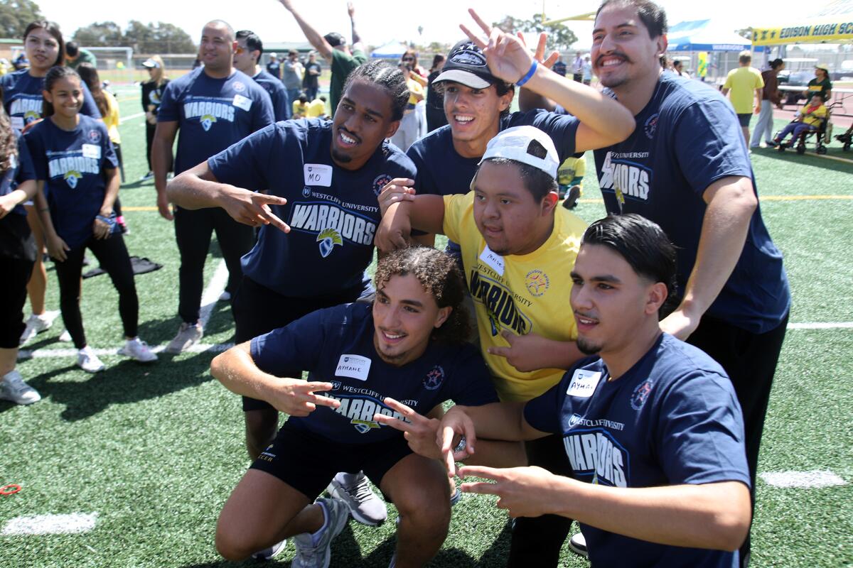 A high school student poses for a picture with student-athletes from Westcliff University on Thursday.