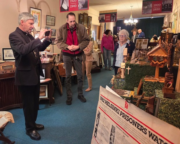 Archbishop Lionginas Virbalas of Lithuania photographs an exhibit at the Lithuanian Heritage Museum in Shenandoah. Peter Cieslukowski and Margaret Valinsky accompany the bishop. RON DEVLIN/STAFF PHOTO