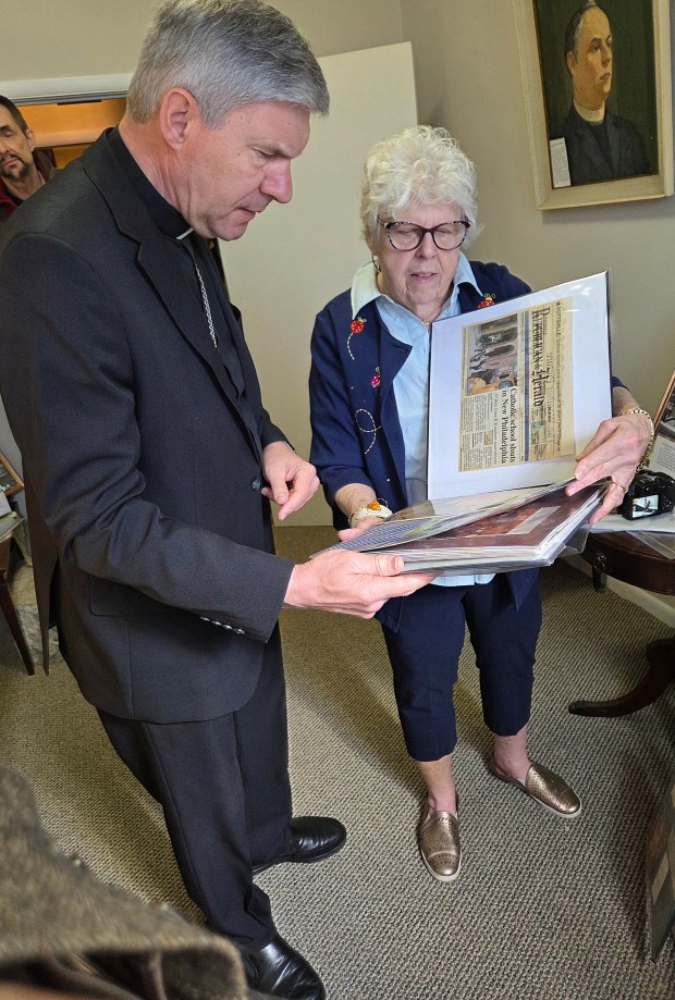 Margaret Valinsky, president of the Lithuanian Women's Club, shows Archbishop Lionginas Virbalas a scrapbook at the Lithuanian Heritage Museum in Shenandoah on April 21, 2026. RON DEVLIN/STAFF PHOTO