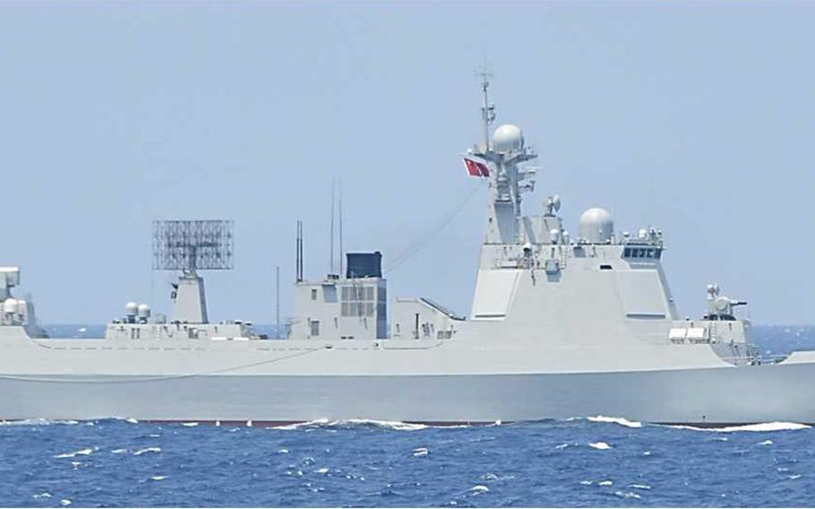 A navy ship sailing in the middle of the ocean. It has the number ‘133” painted on its hull.