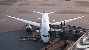An airplane parked by a jet bridge