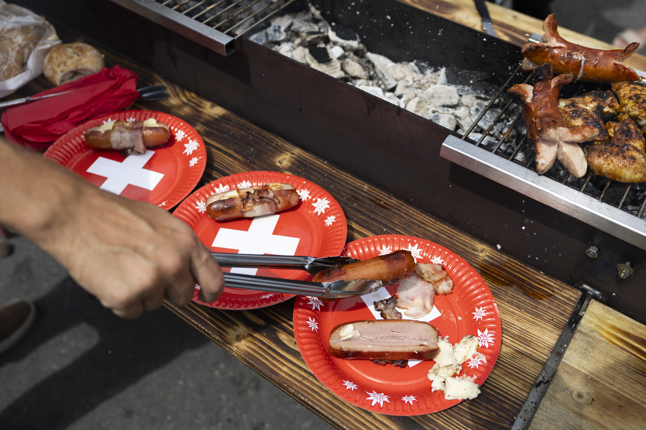 Grilled cervelas on a plate with a Swiss cross.