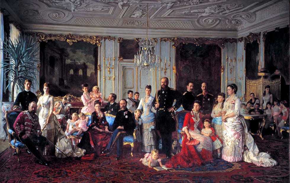 Group portrait of individuals dressed in formal attire in an ornate interior.