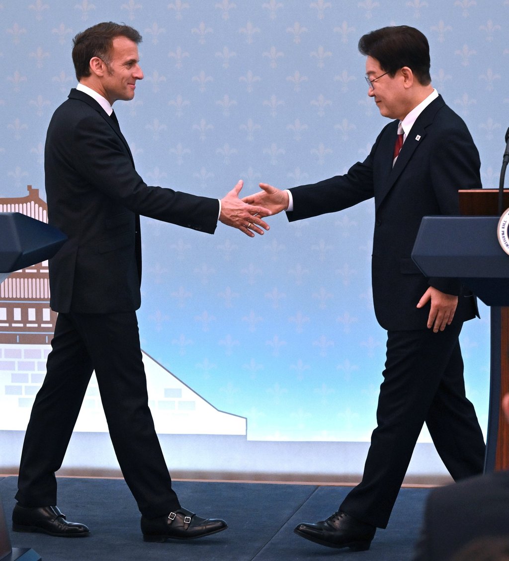 French President Emmanuel Macron (left) shakes hands with his South Korean counterpart Lee Jae Myung during a joint press conference after their meeting at the Blue House in Seoul on Friday. Photo: EPA
