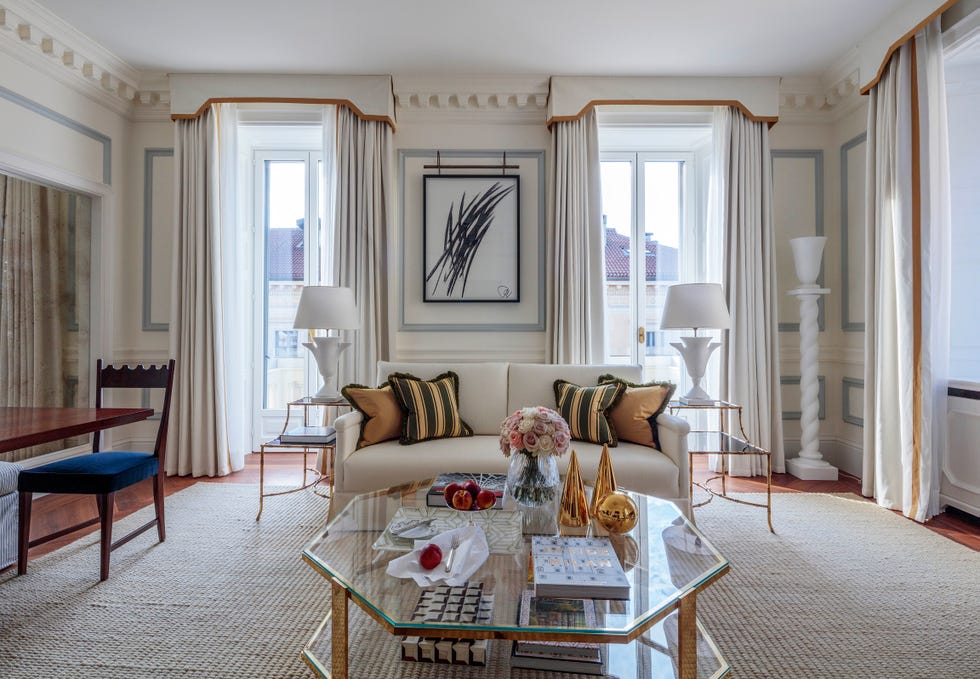 Living room with sofa, drapery, and glass coffee table