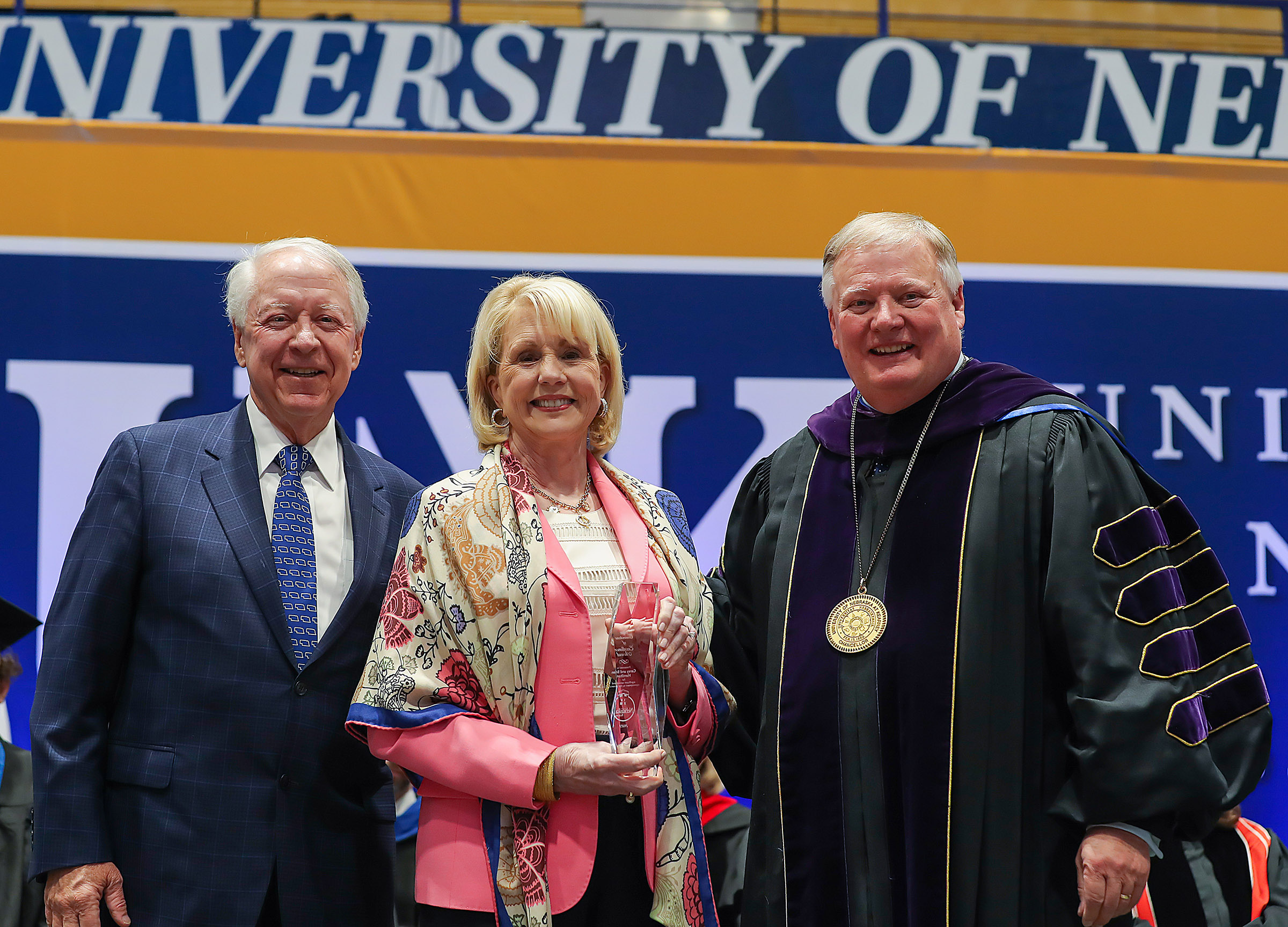 UNK Chancellor Doug Kristensen presents the Ron and Carol Cope Cornerstone of Excellence Award to Brian and Carey Hamilton in 2023.