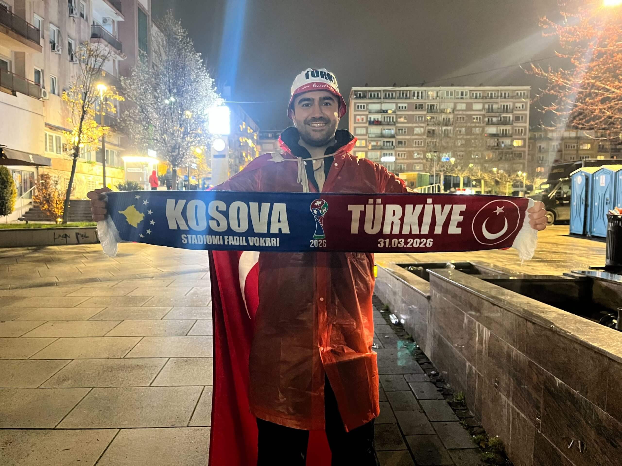 Turkey fan Mehmet Emir Evran holds aloft a half-and-half scarf