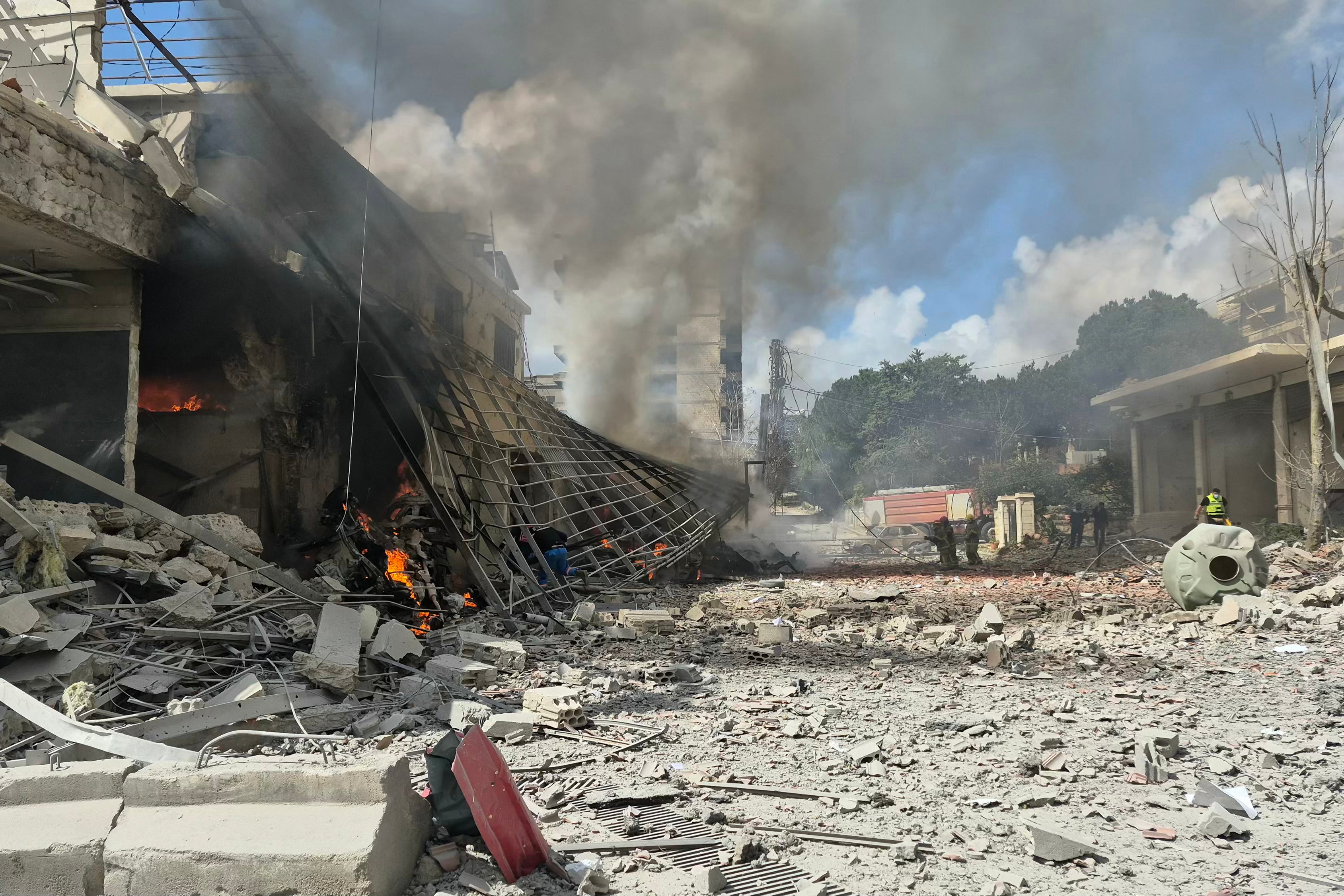 First responders rush to the site of an Israeli airstrike that targeted the Lebanese State Security Center, in the Southern Lebanese city of Nabatieh on Friday