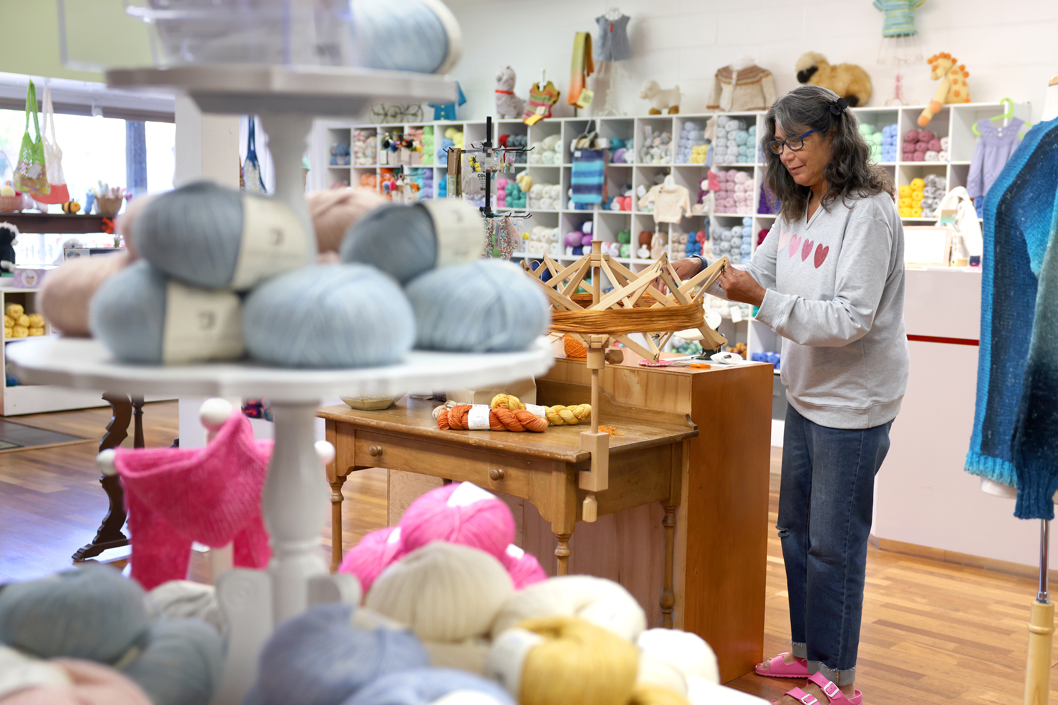Volunteer Janice Orrego winds yarn using a swift at Purls...