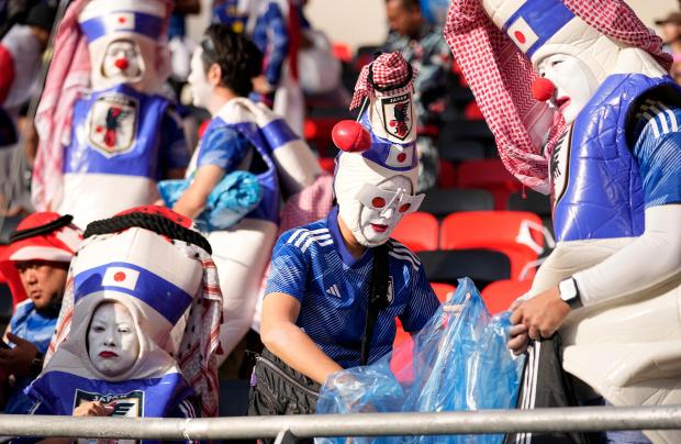 Japanese fans clean the stadium's stand after Japan was defeated by Costa Rica in the World Cup at the Ahmad Bin Ali Stadium in Al Rayyan , Qatar, on Nov. 27, 2022. (AP Photo/Ariel Schalit)
